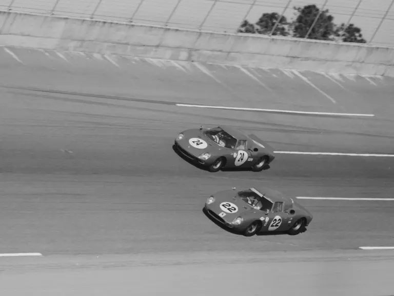 6053 (Car no. 24) co-driven by Innes Ireland, Mike Hailwood, and George Drummond battles Car no. 22, another Ferrari 250 LM, co-driven by Jochen Rindt and Bob Bondurant at the 24 Hours of Daytona, 1966.