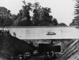 Chassis number 00009/54 in its streamlined configuration, with Stirling Moss (#16) behind the wheel, on the banked Monza circuit during the 1955 Italian Grand Prix.