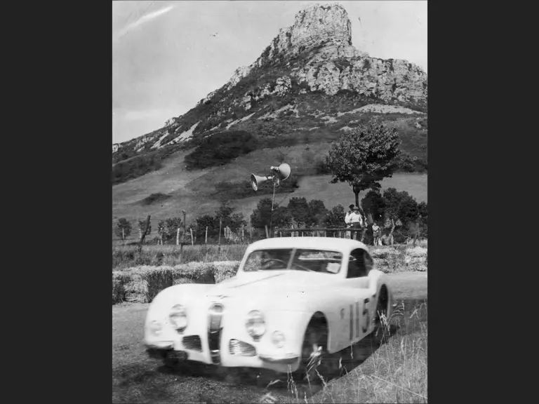 The Talbot-Lago is pictured at a rally, believed to be around 1954. The cliff in the background is La Roche de Solutré, not far from Mâcon, France.