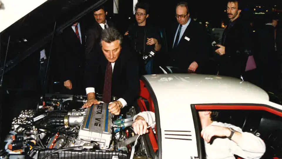 Claudio Zampolli displaying the engine compartment of the Cizeta-Moroder V16T at the 1989 Geneva Auto Salon.