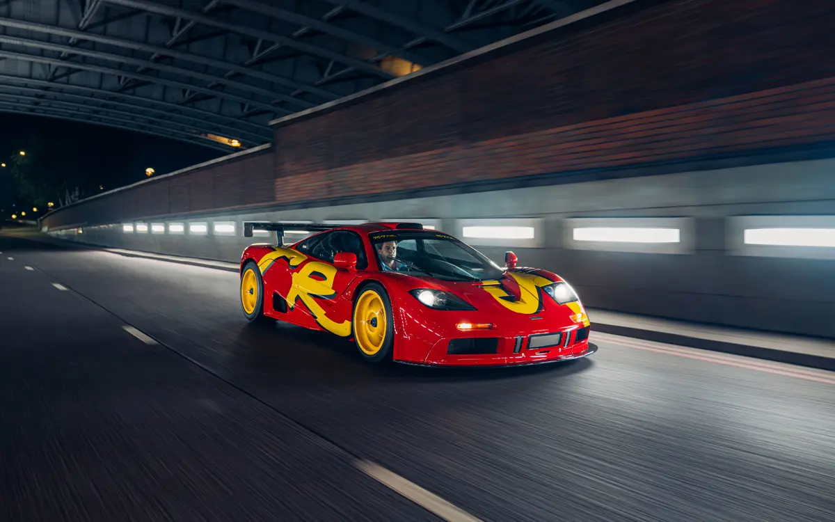 Front three-quarter view of the 1996 McLaren F1 GTR during a nighttime city drive.