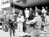 Graham Hill clasping his glass trophy for setting the fastest lap at the 1965 Monaco Grand Prix.
