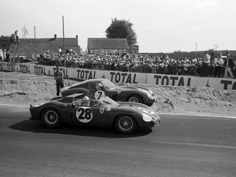 CIRCUIT DE LA SARTHE, FRANCE - JUNE 24: Ricardo Rodriguez / Pedro Rodriguez, SpA Ferrari SEFAC, Ferrari Dino 246 SP, passes Mike Parkes / Lorenzo Bandini, SpA Ferrari SEFAC, Ferrari 330 LM/GTO, beached by the side of the track during the 24 Hours of Le Mans at Circuit de la Sarthe on June 24, 1962 in Circuit de la Sarthe, France. (Photo by LAT Images)