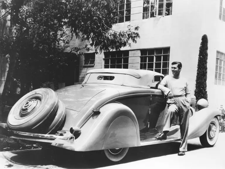 Legendary actor Clark Gable poses with his Duesenberg, his most prized automobile and part of the happiest years of his life.