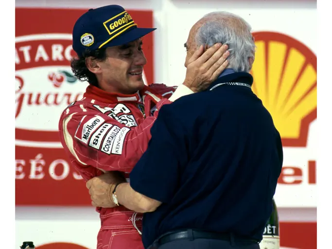 Juan Manuel Fangio embraces Ayrton Senna following his victory at the 1993 Brazilian Grand Prix. Fangio is wearing his treasured Omega Trésor watch on his left wrist.