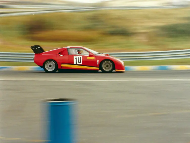 The Ferrari 308 GT/M rounds the sandy, grassy banks of the Zandvoort circuit in the Netherlands.