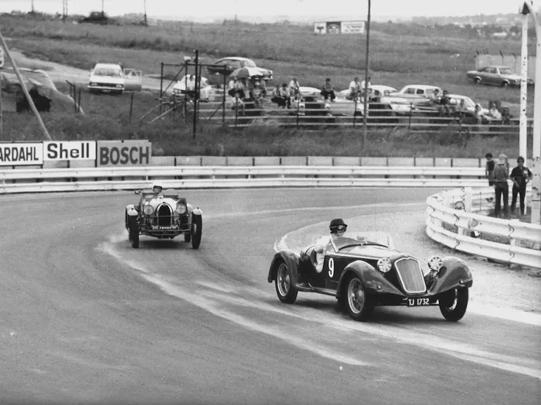 Hugh Gearing and his beloved 6C 1750 outpaces a Bugatti at an event at Kyalami, ca. 1970s.