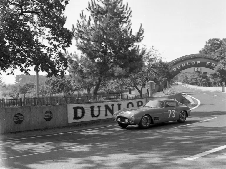 The Ferrari 250 GT Berlinetta hurtles past, driving through the 5th stage of the 1956 Tour de France on 9 July.