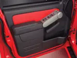 Ford Sport Trac Adrenalin teaser: Ford Sport Trac Adrenalin red-leather interior door trim matches the red seat inserts. 

