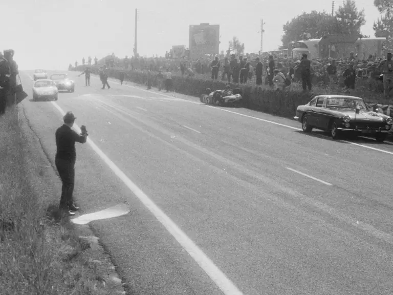 The 1963 Ferrari 250 GTE 2+2 ‘Safety Car’ responds to the upturned wreck of the René Bonnet Aérodjet.