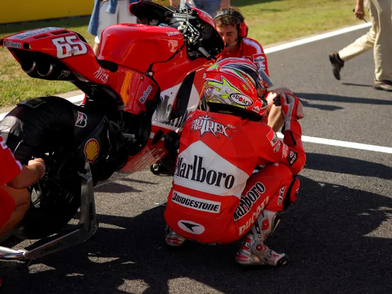 Loris Capirossi waits with the GP6 prior to the start of the MotoGP race at Motegi in 2006.