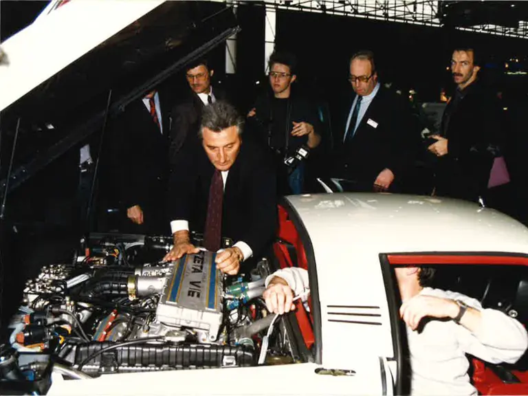 Claudio Zampolli displaying the engine compartment of the Cizeta-Moroder V16T at the 1989 Geneva Auto Salon.