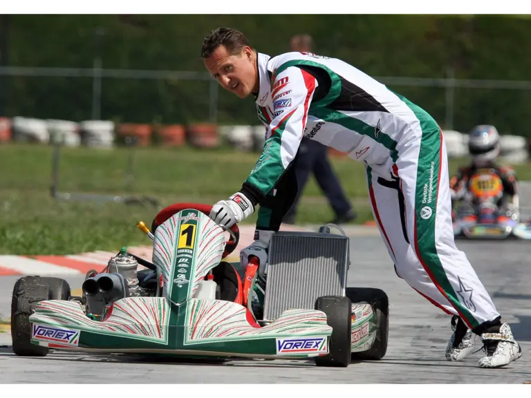 Michael Schumacher pushing his kart down the South Garda Karting track in Italy in 2009. This image is for reference purposes only.