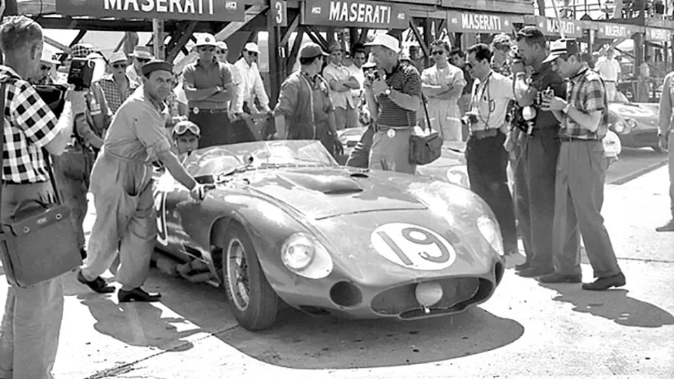 Fangio sits in his race-winning Maserati 450S, chassis number 4503, at the 12 Hours of Sebring in 1957. Pushing the car is the Maserati head mechanic Guerino Bertocchi.