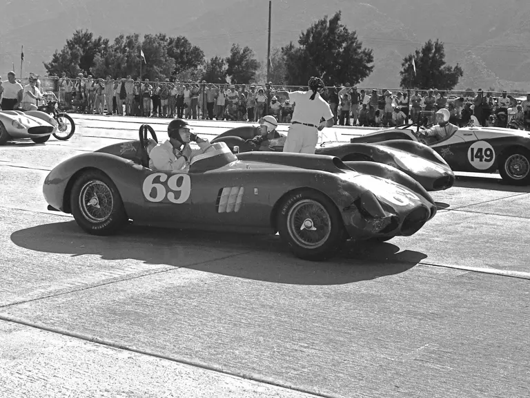 Dan Gurney, behind the wheel of chassis no. 0478 AM (#69), adjusts his helmet prior to the start of the Palm Springs main event race on 13 December 1958. Beside Gurney is Chuck Howard in a Maserati 200S (#111) and Bob Bondurant in a modified Triumph (#149). Gurney would go on to finish 1st overall.