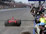 Michael Schumacher takes the chequered flag at the 2006 United States Grand Prix.