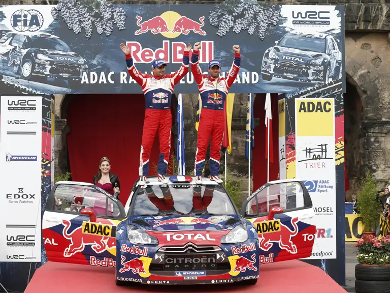 Sébastien Loeb and co-driver Daniel Elena stand atop the Citroën after winning the 2012 Rallye Deutschland.
