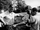 Jack Broadhead with Stirling Moss pointing out a feature of the car to Bob Berry.