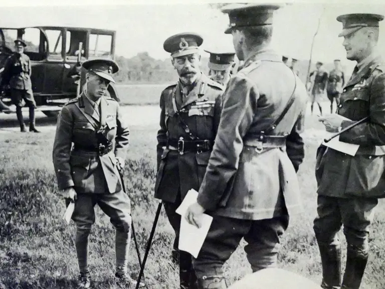 King George V stands with the Prince of Wales, later King Edward VIII, on a wartime visit to France in 1917. Chassis 64RB is seen in the background.