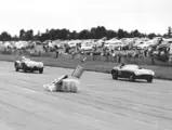 Split seconds after temporary leader Phil Hill hit a course marker, Carroll Shelby, in chassis no. 0478 AM (#103), leads Jack Douglas in a Jaguar C-Type on the main straightaway at the 31 July 1955 SCCA Nationals held at Bremerton, Washington.