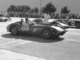 Dan Gurney, behind the wheel of chassis no. 0478 AM (#69), adjusts his helmet prior to the start of the Palm Springs main event race on 13 December 1958. Beside Gurney is Chuck Howard in a Maserati 200S (#111) and Bob Bondurant in a modified Triumph (#149). Gurney would go on to finish 1st overall.