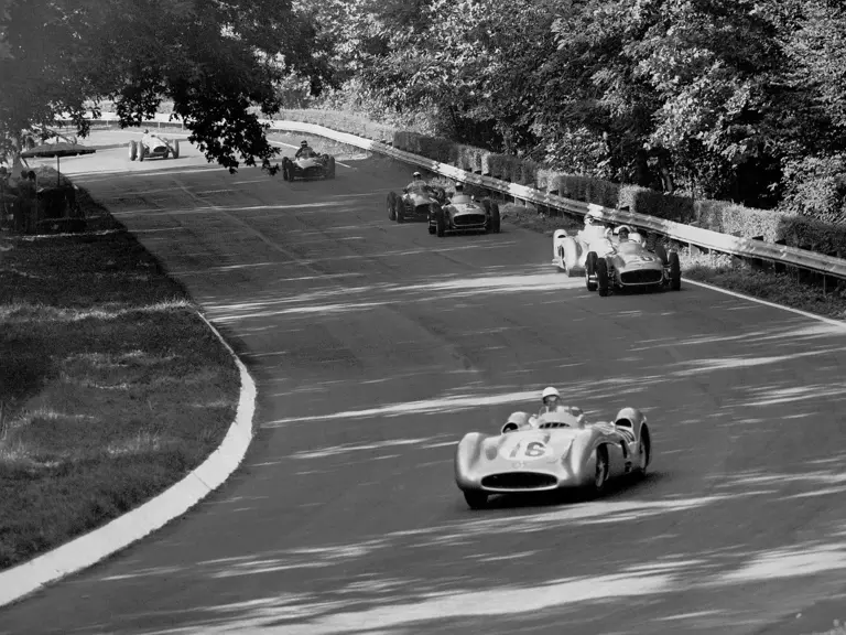 Italian Grand Prix in Monza, 11 September 1955: The four Mercedes-Benz W 196 R Formula One racing cars, two streamlined and two with open-wheel bodywork, are already in the lead on the Lesmo curves. Moss, in the #16 car (chassis number 00009/54), is ahead of Kling, Fangio, and Taruffi.