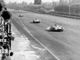 Italian Grand Prix at Monza, 11 September 1955. Eventual winner Juan Manuel Fangio (#18) is followed by Stirling Moss (#16, chassis number 00009/54); both are in Mercedes-Benz Formula One W 196 R racing cars with streamlined bodywork.