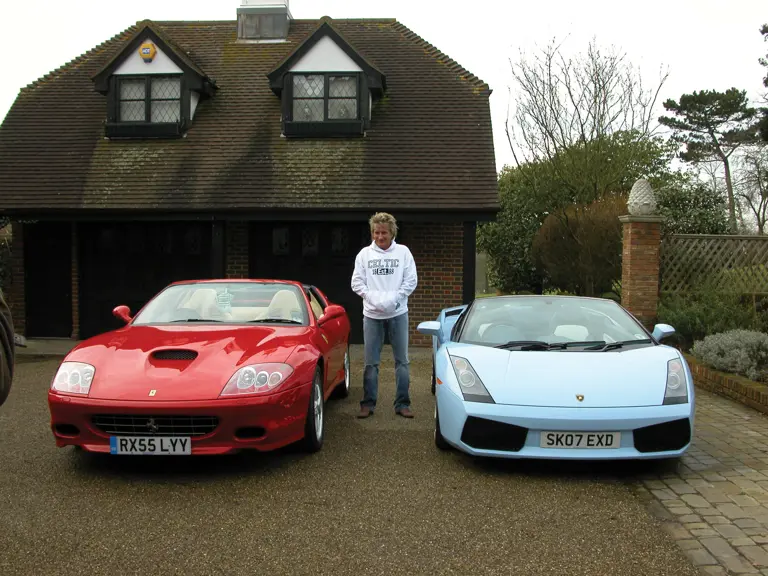 Rod Stewart poses with his Ferrari 575 Superamerica and Lamborghini Gallardo Spyder outside his home in 2009.