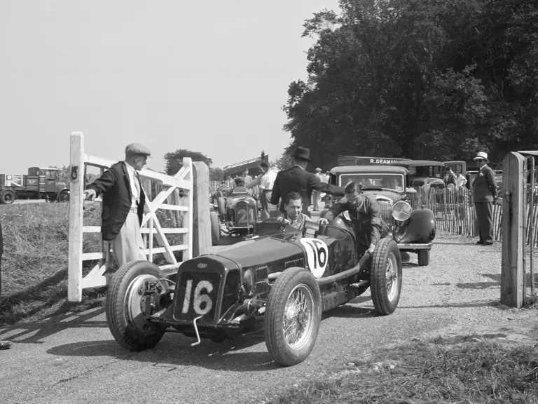 Giulio Ramponi, Richard Seaman’s mechanic, gets a hand out of the paddock at Donington for the British Empire Trophy Meeting, 4 April 1936.