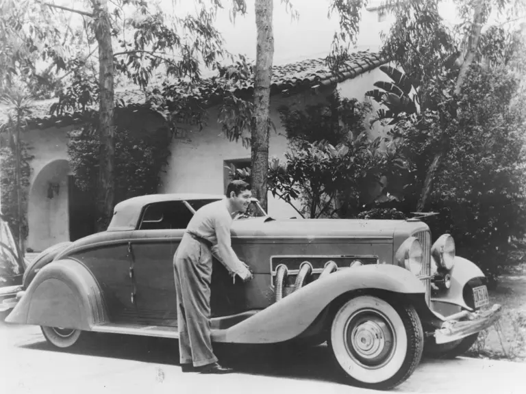 Legendary actor Clark Gable poses with his Duesenberg, his most prized automobile and part of the happiest years of his life.