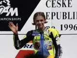 A 17-year-old Valentino Rossi waves on the podium as he awaits his first-place trophy at the 1996 Czech Grand Prix.
