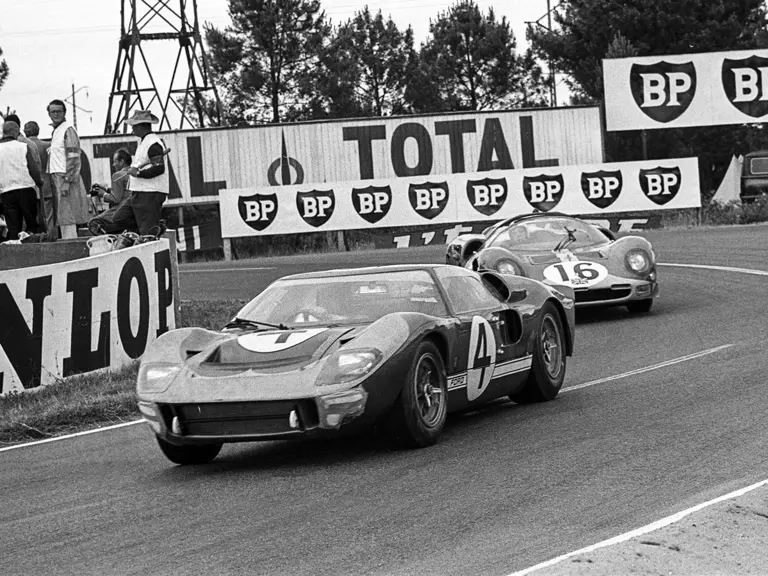 Holman-Moody’s #4 car (P/1032) driven by Mark Donohue and Paul Hawkins leads Maranello Concessionaires’ #16 Ferrari 365 P2 driven by Richard Attwood and David Piper at the 1966 24 Hours of Le Mans.