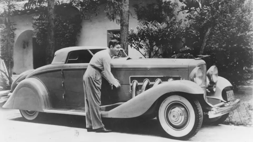 Legendary actor Clark Gable poses with his Duesenberg, his most prized automobile and part of the happiest years of his life.