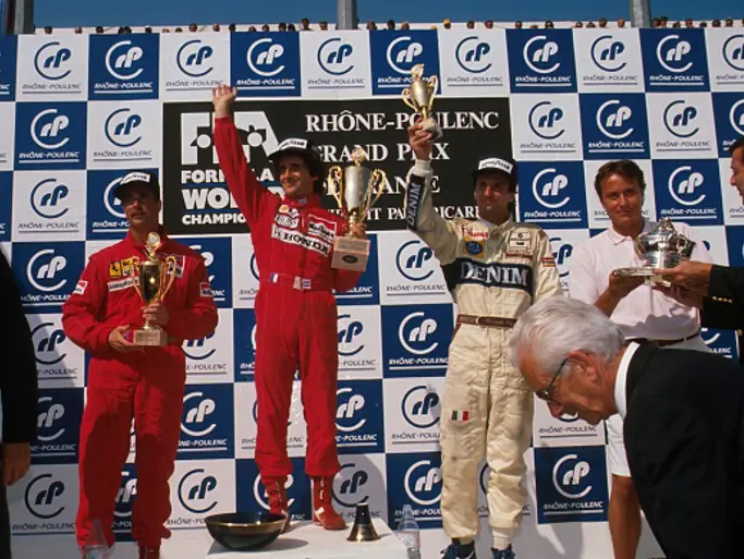 Nigel Mansell stands on the podium with Alain Prost and Riccardo Patrese after finishing 2nd at the 1989 French Grand Prix.