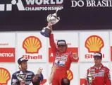 Ayrtona Senna lifts the 1st place trophy following his herculean drive at the 1991 Brazilian Grand Prix.