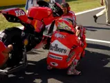 Loris Capirossi waits with the GP6 prior to the start of the MotoGP race at Motegi in 2006.