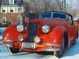 The Alfa Romeo is pictured in Chicago in the 1960s. Compared to earlier appearances, the car has notably lost its single wing-mounted mirror and lights in addition to the windscreen attachments.