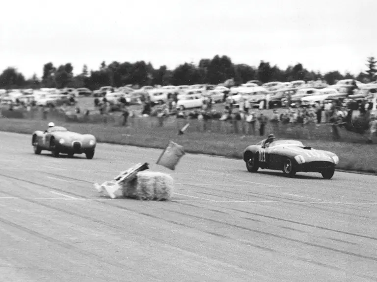 Split seconds after temporary leader Phil Hill hit a course marker, Carroll Shelby, in chassis no. 0478 AM (#103), leads Jack Douglas in a Jaguar C-Type on the main straightaway at the 31 July 1955 SCCA Nationals held at Bremerton, Washington.