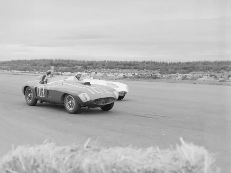 Carroll Shelby, behind the wheel of chassis no. 0478 AM (#103), gives a friendly wave to Phil Hill and his 750 Monza (#3) after beating him in the feature race at the 31 July 1955 SCCA Nationals held at Bremerton, Washington.