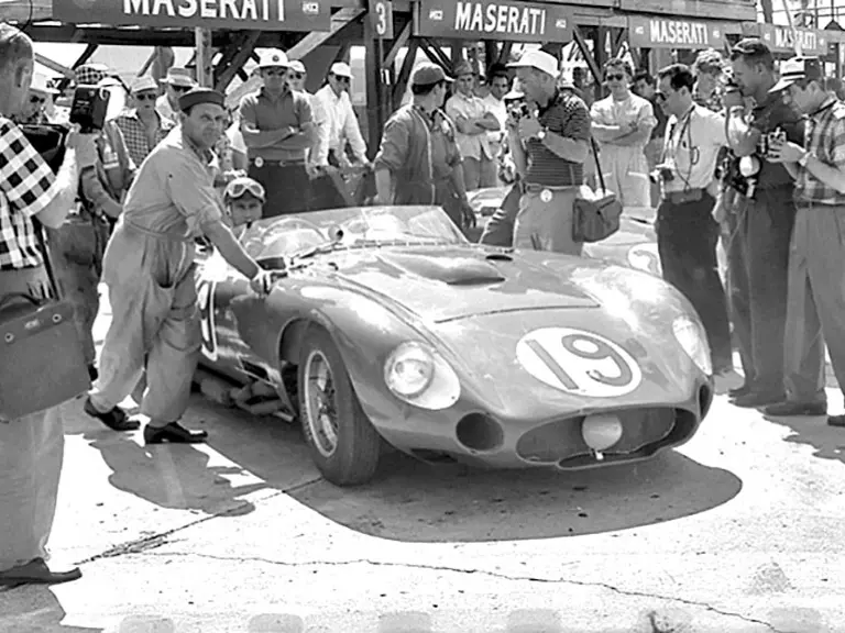 Fangio sits in his race-winning Maserati 450S, chassis number 4503, at the 12 Hours of Sebring in 1957. Pushing the car is the Maserati head mechanic Guerino Bertocchi.