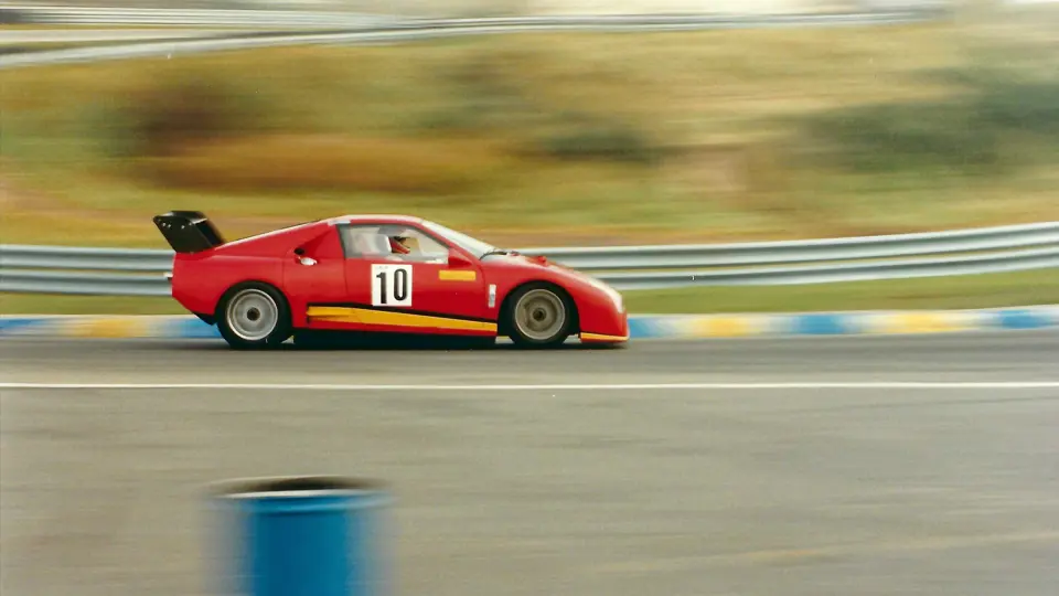 The Ferrari 308 GT/M rounds the sandy, grassy banks of the Zandvoort circuit in the Netherlands.