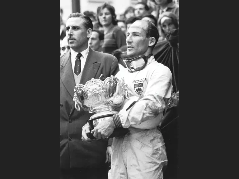 Stirling Moss stands proudly holding the 1st-Place Trophy he won at the 1961 Monaco Grand Prix.