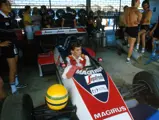 Senna’s unmistakable helmet balances on the suspension of the Toleman in the pit garage in Brazil.