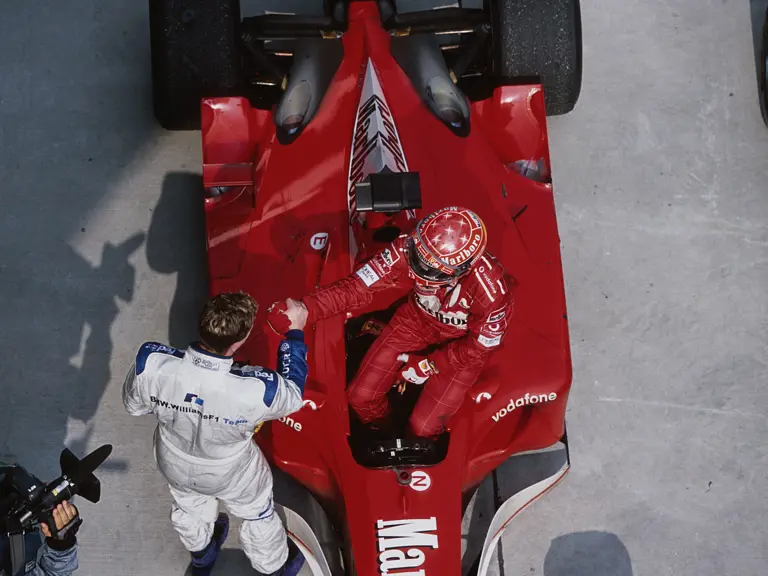 Ralf Schumacher celebrates with brother Michael in parc ferme during the Malaysian GP at Sepang International Circuit on March 17, 2002 in Sepang International Circuit, Malaysia.