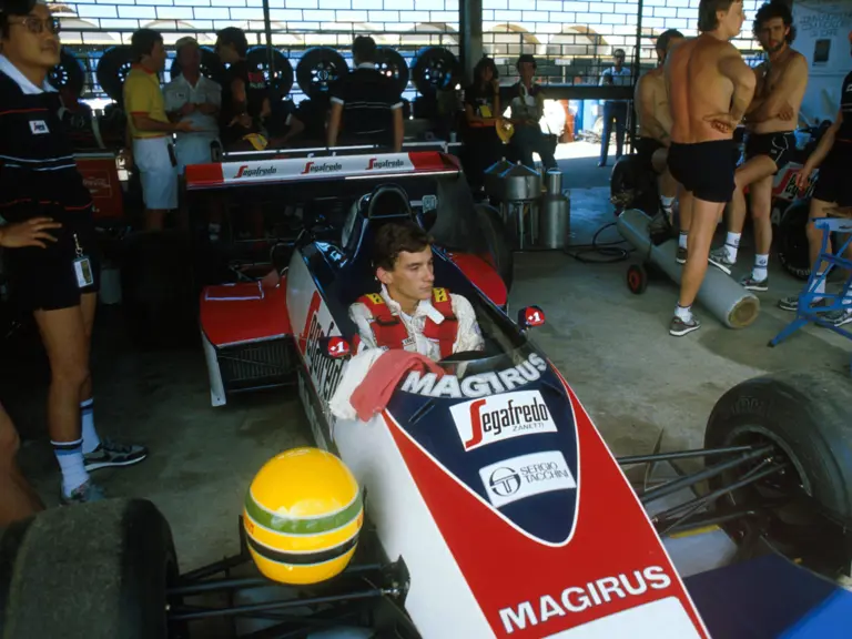 Senna’s unmistakable helmet balances on the suspension of the Toleman in the pit garage in Brazil.